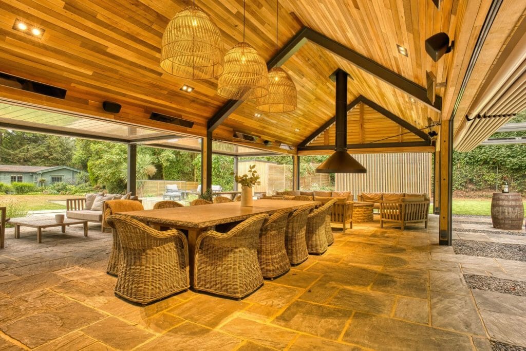 Wood living area outside with wicker chairs and heating by Bromic 